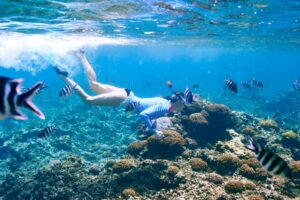 Woman with mask snorkeling in clear water